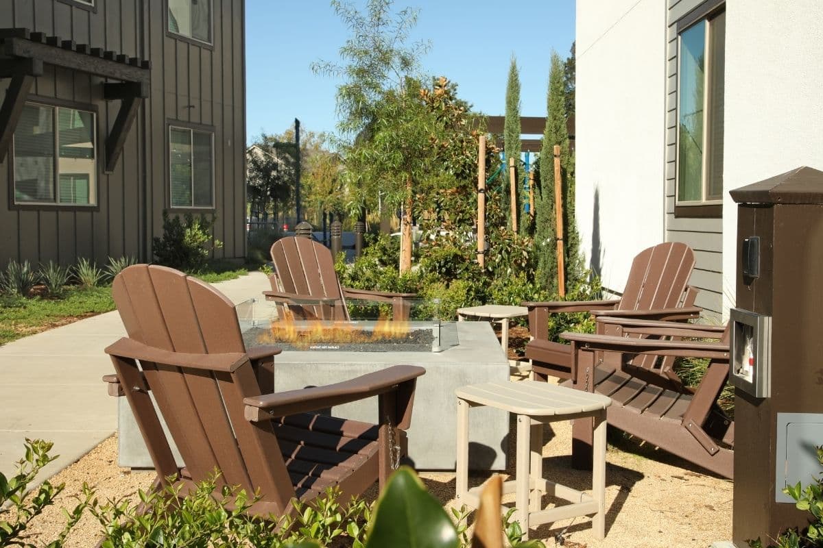 Outdoor fire table lounge area for residents at The Strand Apartments