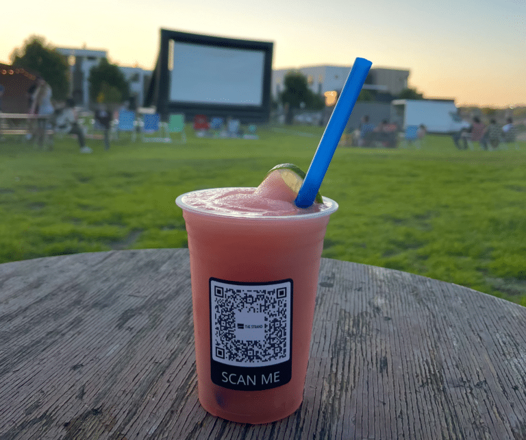 Frozen drink on table in front of outdoor movie